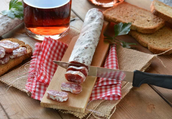 Salame fuet espanhol em uma tábua de corte — Fotografia de Stock