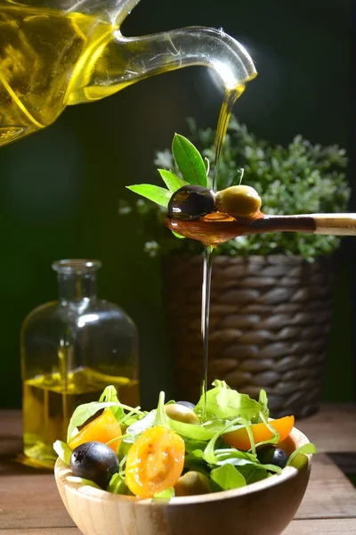 Olive oil falling on two olive with olive leaves — Stock Photo, Image