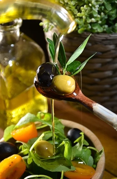 Olive oil falling on two olive with olive leaves — Stock Photo, Image