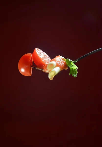 Fork with macaroni, oregano and tomatoes — Stock Photo, Image