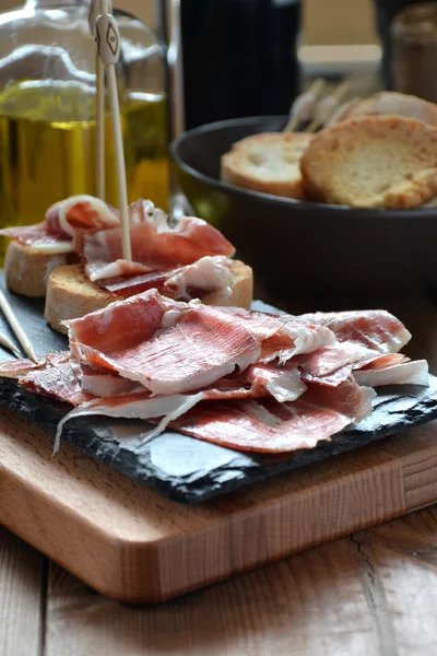 Appetizer of ham Serrano with bread roasted — Stock Photo, Image