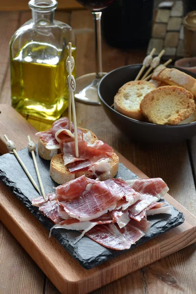 Appetizer of ham Serrano with bread roasted — Stock Photo, Image