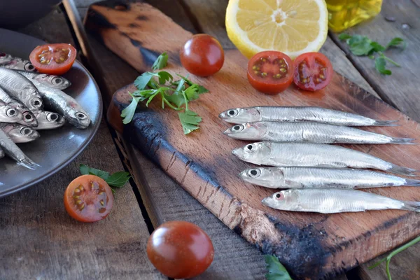 Anchovas frescas, colocadas sobre uma mesa de madeira — Fotografia de Stock