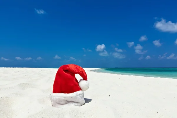 Kerstman hoed is op een strand — Stockfoto