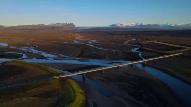 4K letecké záběry auta jedoucího na nejmalebnější a nejkrásnější Ring Road číslo 1 na Islandu přes ledovcové řeky během zlaté hodiny. Cestovní ruch na Islandu — Stock video