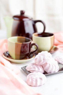 Kremalı Rus çileği ve parlak bir masa üzerinde çay. natürmort, seçici odaklanma. dikey