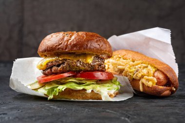 Fast food, sosisli ve hamburger. Öğle yemeği için sağlıklı atıştırmalıklar. Fast food konsepti menüsü. Boşluğu kopyala, seçici odak.