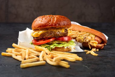 Fast food, sosisli sandviç, hamburger ve patates kızartması. Öğle yemeği için sağlıklı atıştırmalıklar. Fast food konsepti menüsü. Boşluğu kopyala, seçici odak.