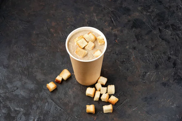 French cuisine hot food delivery - Close-up of mushroom soup in disposable paper cups on a dark stone surface. Healthy food concept, menu, Copy space — Stock Image French Cuisine Hot Food Delivery Close Mushroom Soup Disposable Paper Stock Picture
