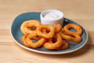 Soslu kızarmış soğan halkaları. Tahta arka planda. Uzayı kopyala Lokantada bira menüsü