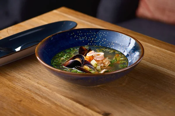 Deliciosa sopa de mariscos con mariscos, camarones y mejillones sobre una mesa de madera — Foto de Stock