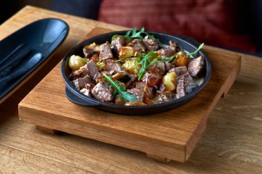 Geleneksel İsviçre yemeği. Kremalı soslu dana eti. Masada sahte bir tavaya yakın plan..