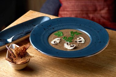 Tahta masada yabani mantarlı lezzetli çorba püresi. bir restoranda servis yapmak, menü.