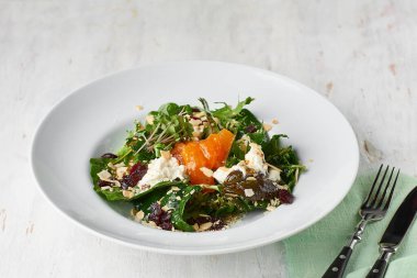 Ev yapımı stracciatella ile sağlıklı bir salata. Hurmalı, kurutulmuş yaban mersinli ve kırsal bir zeminde badem taneli. Vejetaryen menüsü, sağlıklı yiyecekler. Vitamin eksikliğinin önlenmesi.