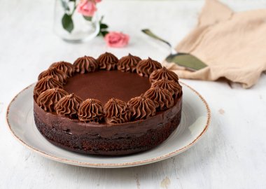 Hafif ahşap arka planda çikolata soslu süper çikolatalı pasta. seçici odak