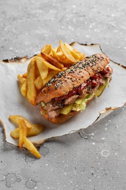 Kızarmış sığır filetosuyla kruvasan sandviç, güneşte kurutulmuş domates, taş dokuda sos. Sağlıklı, lezzetli, besleyici atıştırmalıklar. Yemeği götür.