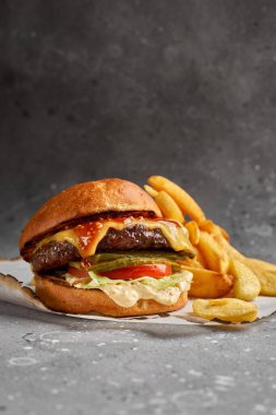 Amerikan mutfağı. Salatalık, peynir ve soslu mermer biftekli Royal Cheese Burger. Sağlıklı, lezzetli, besleyici atıştırmalıklar.