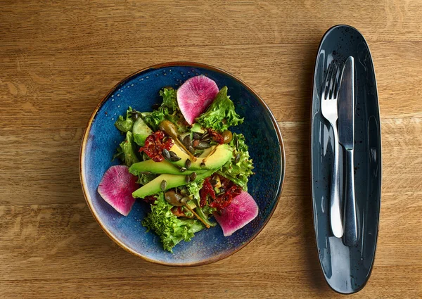 Menú de dieta. La ensalada sana hortalizas frescas - el aguacate, la rúcula, el rábano en la escudilla. Comida vegana. Puesta plana. — Foto de Stock