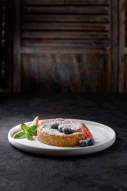 Crack Pie, American dessert with a rich salty-sweet taste on an oatmeal basis, on a black stone background. Banner