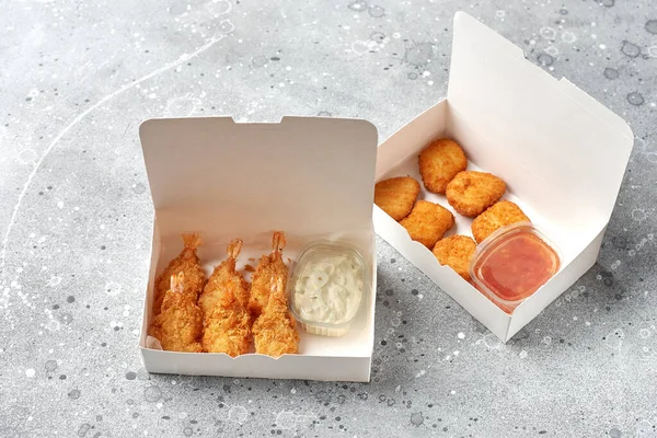 food delivery, takeaway food with fried shrimps in batter and hot chicken nuggets. paper containers, menu and logo mockup