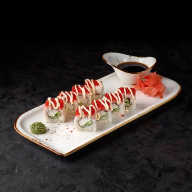 Masago 'lu California Maki suşisi. Yengeç eti, Avokado, içinde salatalık. Siyah arka planda Masago eritilmiş yumurta. Suşi menüsü. Japon yemeği..