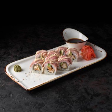 Roll Nivatori, tavuk filetosu, salatalık, pastırma ve siyah arka planda baharatlı sos. Suşi menüsü. Japon yemeği..