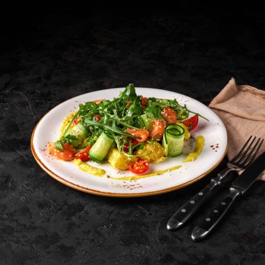 Hafif tuzlu somon salatası ve siyah arka planda safran soslu patates. Aperatif ya da atıştırmalık. Seçici odaklanma. menü