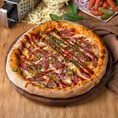 Mozzarella peynirli lezzetli pizza, sosis, turşu, kırmızı soğan, Fransız hardalı, barbekü sosu. Piknik şirketi için fast food, menü için fotoğraf. İtalyan mutfağı.