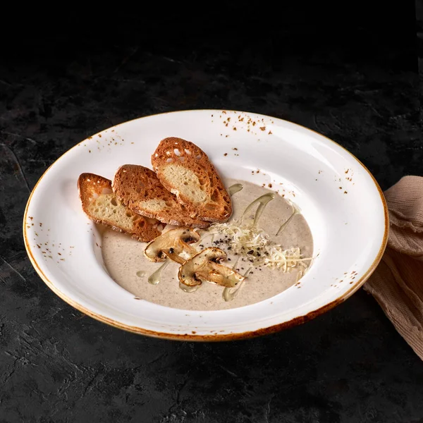 Sopa de crema de diferentes tipos de champiñones, cebollas y crema sobre fondo de piedra oscura — Foto de Stock