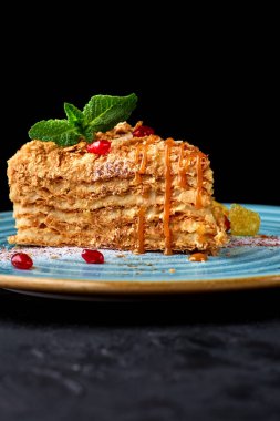 Krem rengi Napoleon Millefeuille vanilya dilimli, koyu arkaplanlı bir pasta. kopyalama alanı. Seçici odaklanma. menü