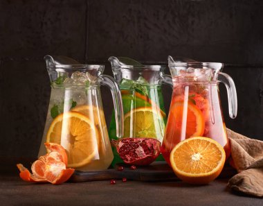 Sürahilerde renkli limonata seti. Koyu arkaplanda