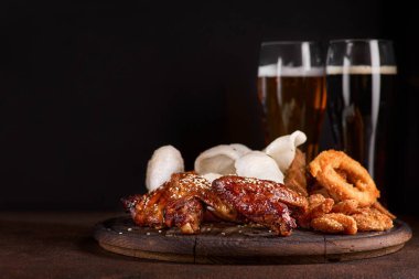 Bira seti. Karides cipsi, kızarmış kalamar halkaları, sarımsaklı ekmek, peynir çubukları. Arkadaş için iki bardak bira, menüde bir fotoğraf..