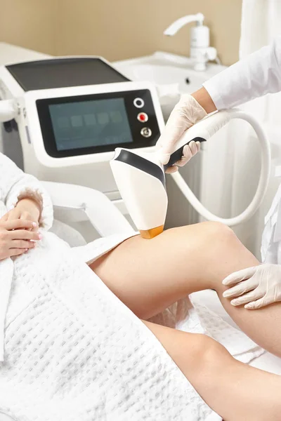 Cosmetologia. Giovane donna al salone Spa che riceve la procedura di depilazione laser. Estetista utilizzando apparati moderni per le procedure termali. Cura della pelle e bellezza. — Foto Stock