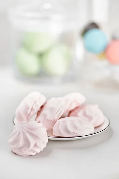 Zarte mehrfarbige Marshmallows auf weißem Teller. Stillleben mit Marshmallows rosa auf einem hellen Tisch. — Stockfoto