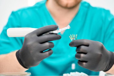 Diş hekiminin elini dişindeki sinirleri sökmek için özel bir aletle kapat. Diş hekimi ortopedist araçları.