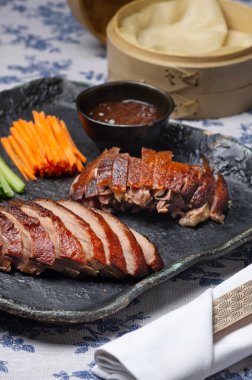 Geleneksel Pekin ördeği salatalık dilimleri, soğanlar ve hoisin sosuyla servis edilir. Zarif bir ziyafet için tasarlanmıştır..