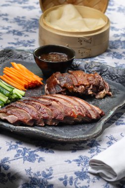 Geleneksel Pekin ördeği salatalık dilimleri, soğanlar ve hoisin sosuyla servis edilir. Zarif bir ziyafet için tasarlanmıştır..