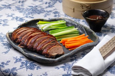 Geleneksel Pekin ördeği salatalık dilimleri, soğanlar ve hoisin sosuyla servis edilir. Zarif bir ziyafet için tasarlanmıştır..