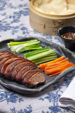 Geleneksel Pekin ördeği salatalık dilimleri, soğanlar ve hoisin sosuyla servis edilir. Zarif bir ziyafet için tasarlanmıştır..