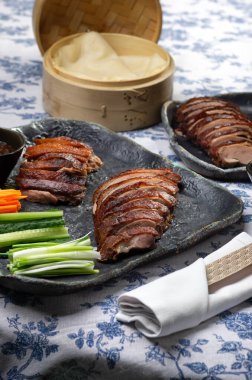 Geleneksel Pekin ördeği salatalık dilimleri, soğanlar ve hoisin sosuyla servis edilir. Zarif bir ziyafet için tasarlanmıştır..