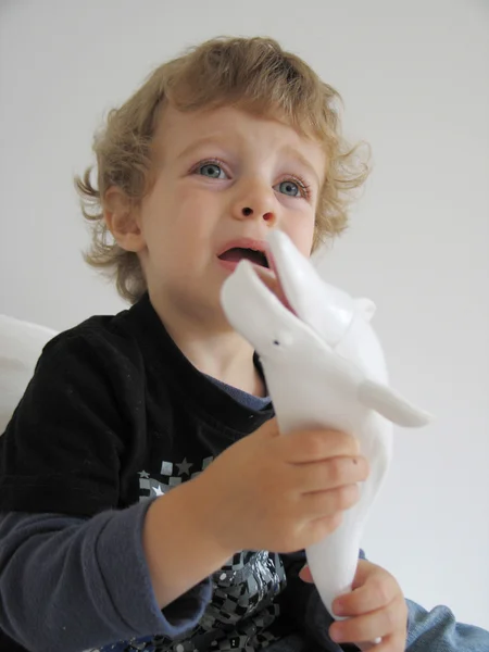 Bonito menino detém brinquedo de baleia — Fotografia de Stock