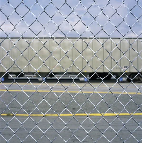 Bir zincir bağlantı çit üzerinden tren araba — Stok fotoğraf