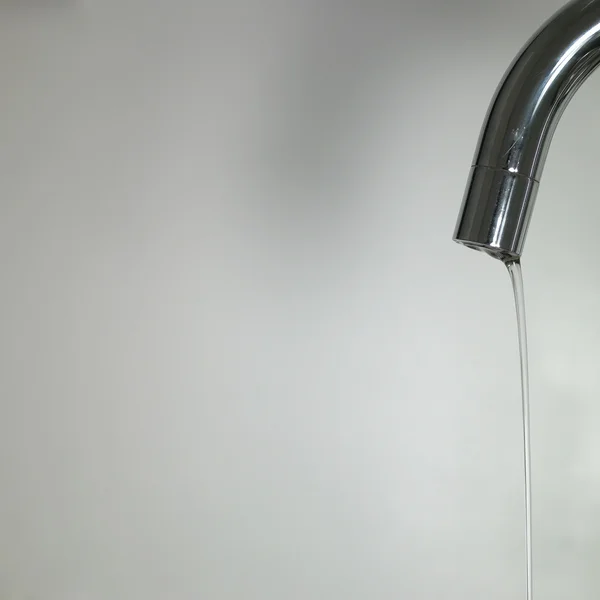 Wasser läuft aus dem Wasserhahn Stockbild