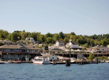 Winnipesaukee Gölü, New Hampshire - Ağustos 2008: Weirs Sahili 'nin rıhtımındaki binaların önündeki iskeleye demirlemiş teknelerin geniş açı manzarası