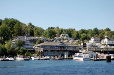 Winnipesaukee Gölü, New Hampshire - Ağustos 2008: Weirs Sahili 'nin rıhtımındaki binaların önündeki iskeleye demirlemiş teknelerin geniş açı manzarası