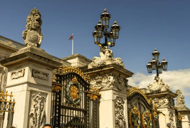 Buckingham Sarayı 'nın kapılarını sütunlar üzerine oyulmuş detaylarla yakından inceleyin. İşlenmiş demir kapılar siyah ve altınla boyanmıştır. Dizaynın içine bir arma yerleştirildi.