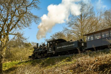 Merthyr Tydfil, Galler - Nisan 2018: Brecon Dağı Demiryolu kırsalından geçen bir buhar treninin geniş açılı görüntüsü