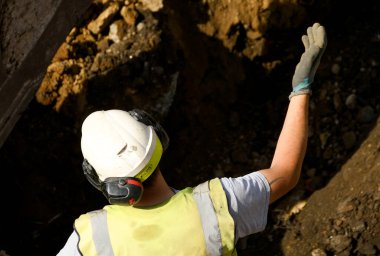 Pontypridd, Galler - Mayıs 2018: Eski bir alışveriş merkezinin şantiyesinde önemli bir gelişme olan Şekerleme Vadisi yenilenme projesinin temellerini kazan bir kazıcı yöneten inşaat işçisi.