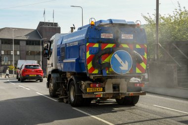 Pontypridd, Wales - Mayıs 2018: Aracın arkasından çıkan tozla caddeyi temizleyen bir yol temizleyicisi