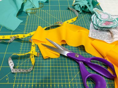 Boyama makası, mezura ve ölçü işaretli sarı kumaş.